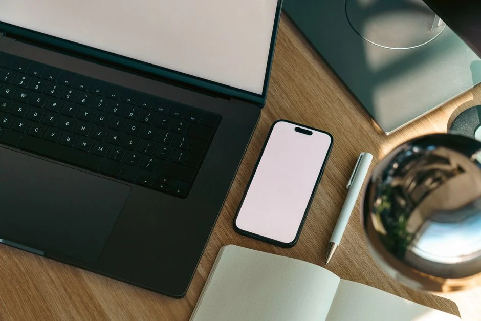 Stylish indoor workspace with a tablet, coffee cup, and magazines on a white table.